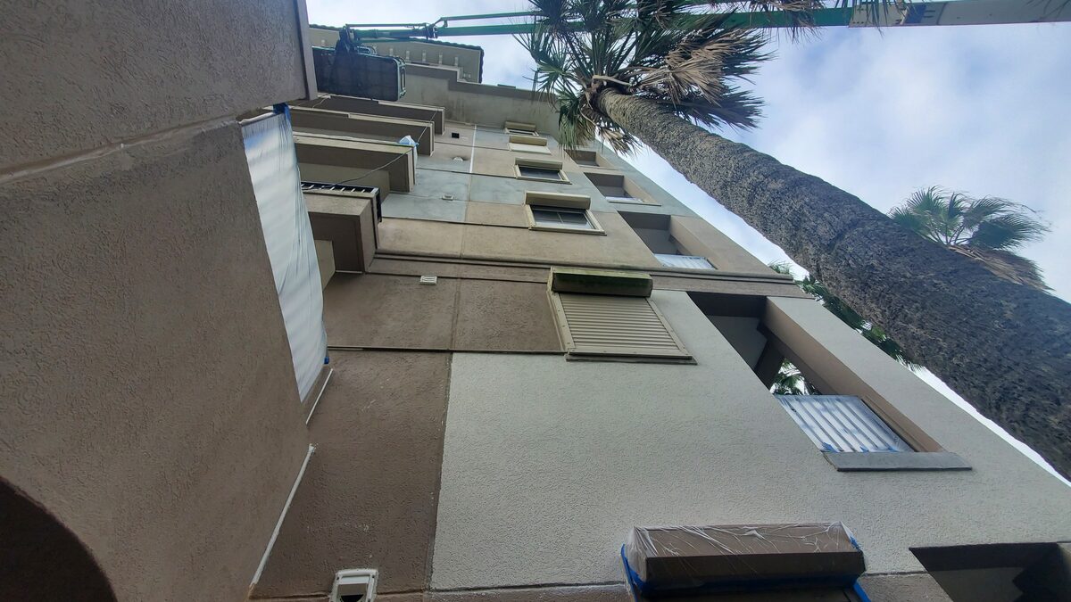 Windows protected with masking during an exterior envelope project on a Florida mid-rise condominium