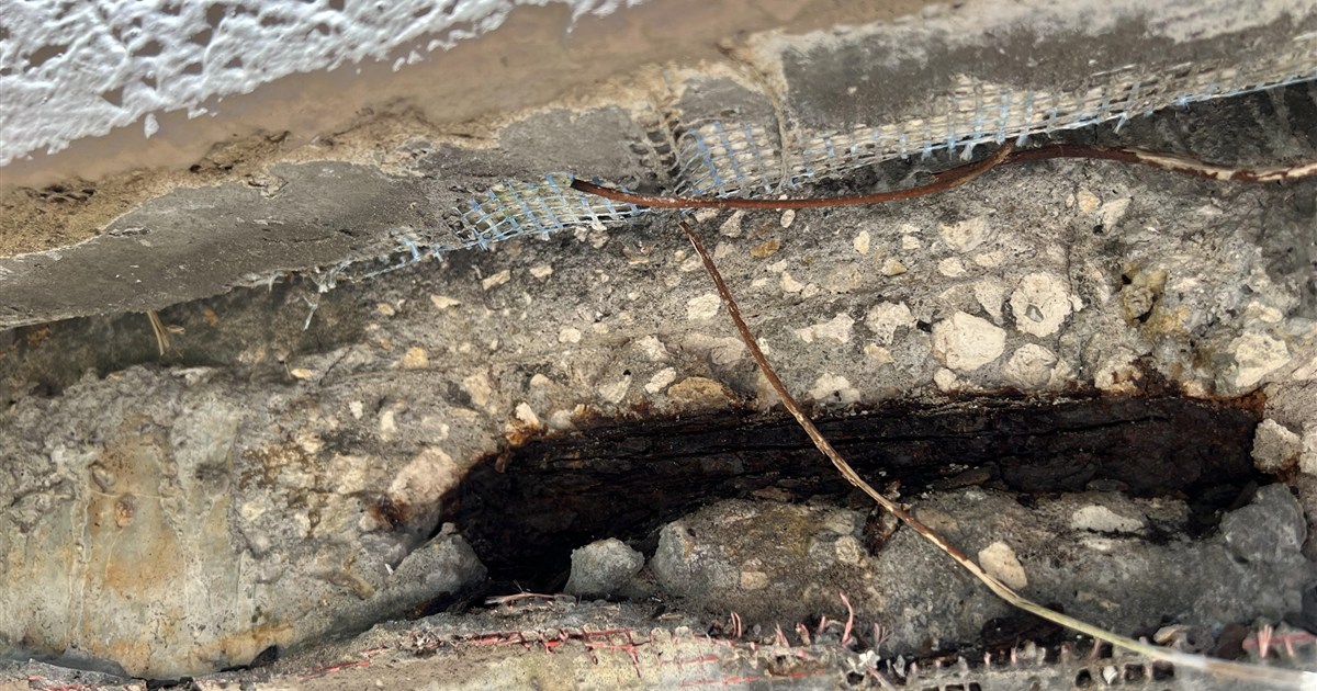 Aerial view of a coastal Florida condominium building undergoing structural inspection.