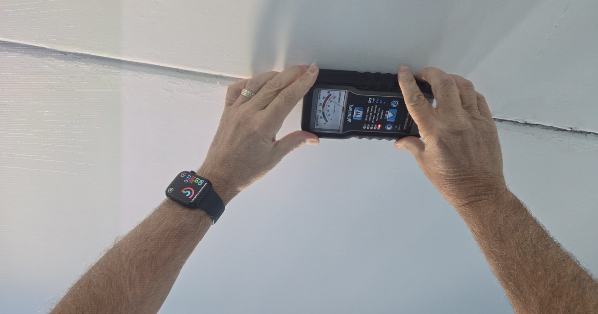 Moisture meter reading taken on a water-damaged ceiling during a CSI building evaluation