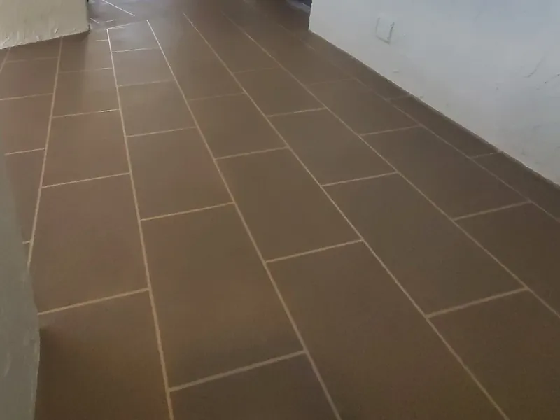 Taupe walkway floor with a larger rectangular decorative pattern.
