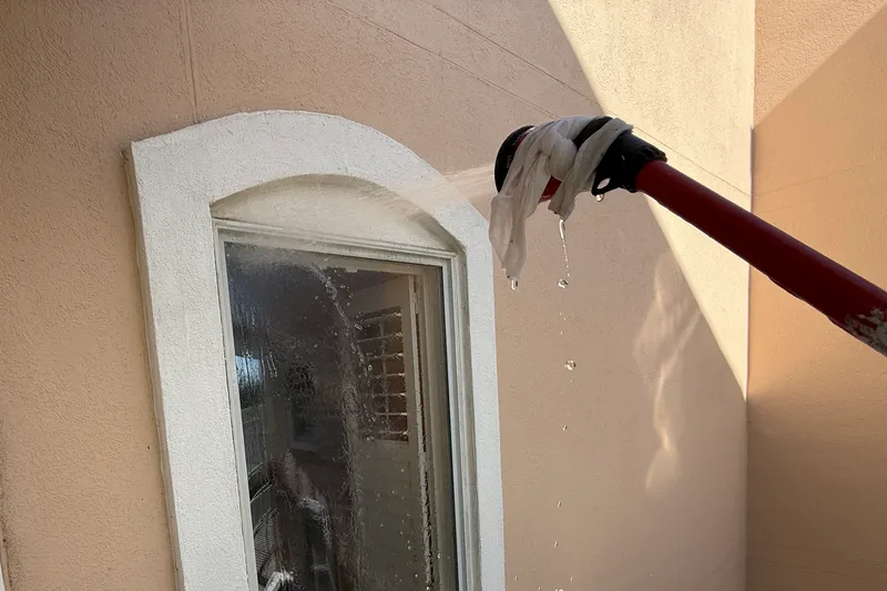 Water from a test nozzle is directed at an exterior window and its trim.