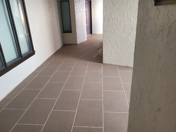 The installed decorative waterproofing finish follows the existing walkway geometry.