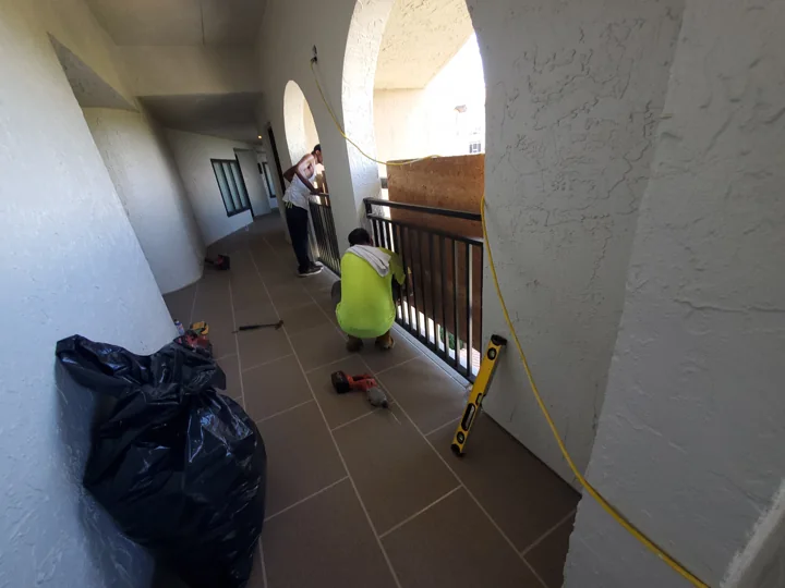 Railing work continues beside the newly finished walking surface.