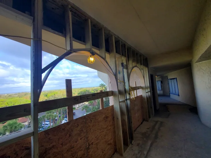 Exposed framing shows the shape of the reconstructed breezeway arches before the finish is applied.