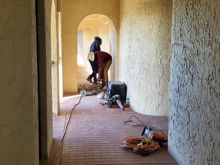 Tile removal underway in a protected walkway work area.