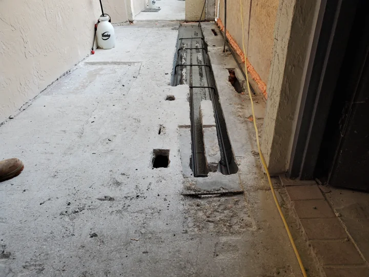 Opened concrete repair areas reveal the work beneath the walking surface.