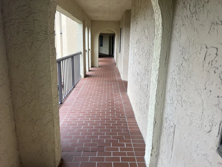 Red tile, cream walls, and the original railing arrangement along a Sea Dunes walkway.