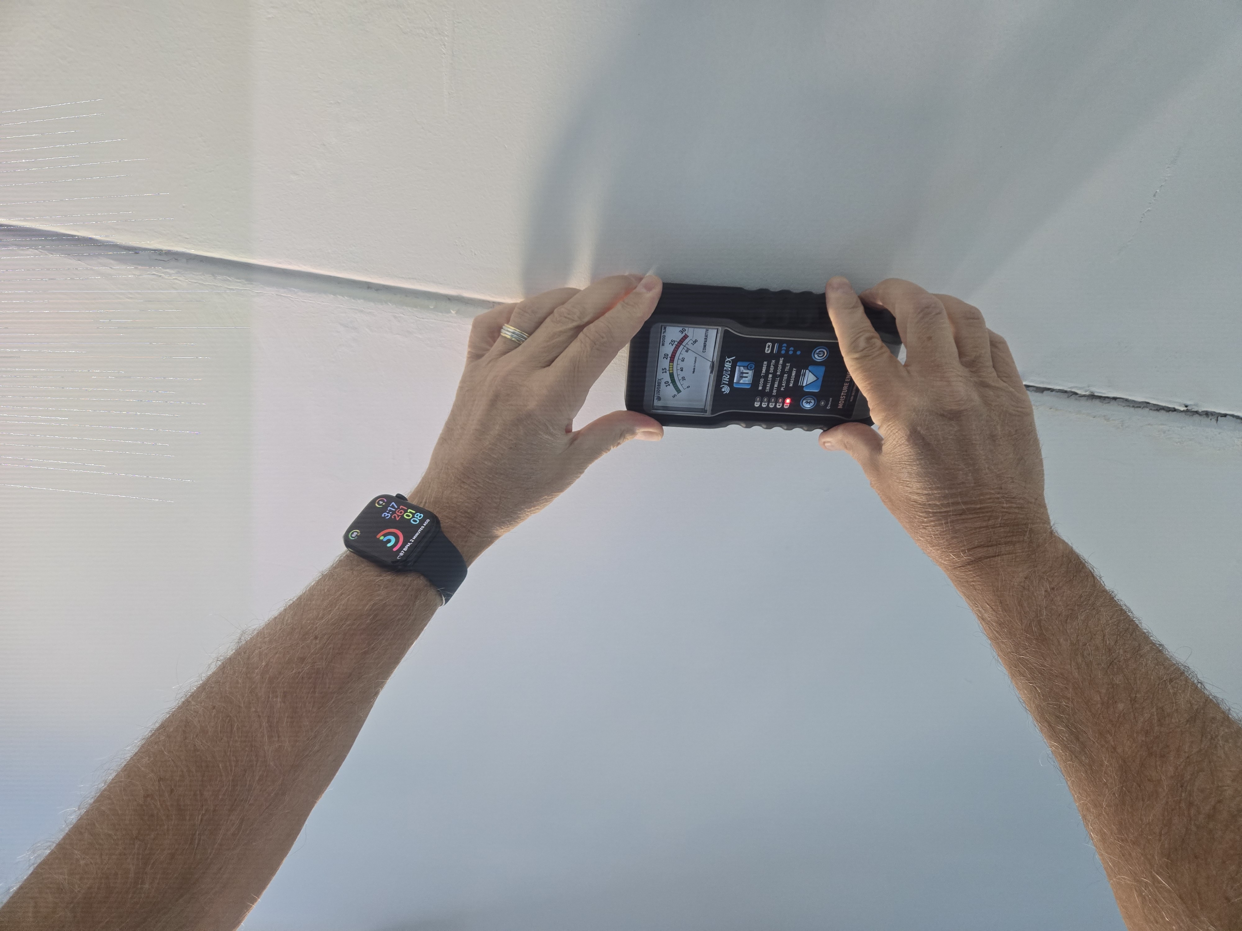 Tramex moisture meter readings during ceiling water damage testing in Florida building