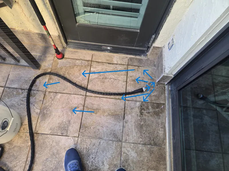 Report photograph of a balcony at a sliding glass door with arrows drawn to show where water entered and the path it followed