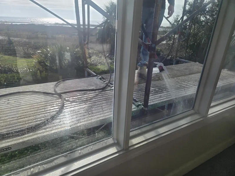 View from inside a condominium unit during a water test, with water spraying on the exterior of the window